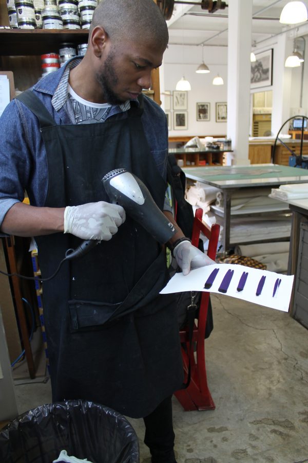 Sbongiseni then dries each colour test with a hair dryer to compare the colour with the sample in a dried state, when the ink's hue can change.