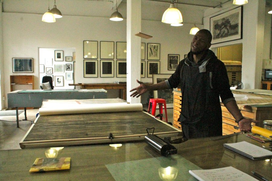Sbongiseni prepares for a serious day of woodcut printing at AOM.