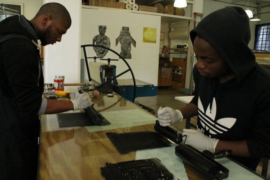 Martin helps to lather the rollers in ink, applying an even spread across the surface. 