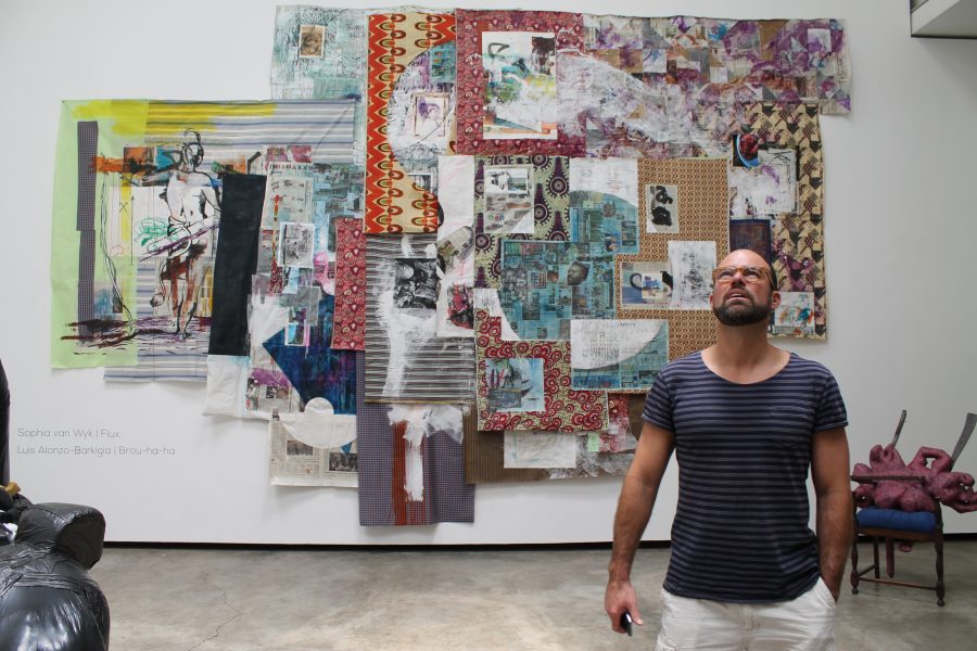 Alonzo-Barkigia in front of his giant collage and ink piece, Untitled (2015).