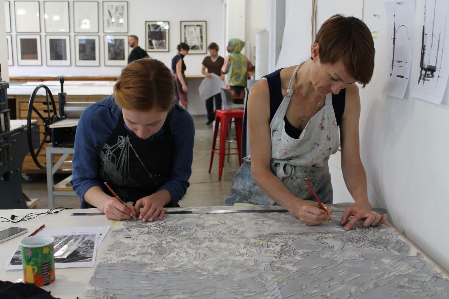 Robyn Penn (right) etches large cloud print.